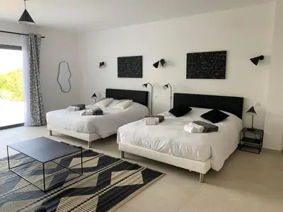 a bedroom with two beds and a table at VILLA IMPERIALE vue mer piscine in Pietrosella