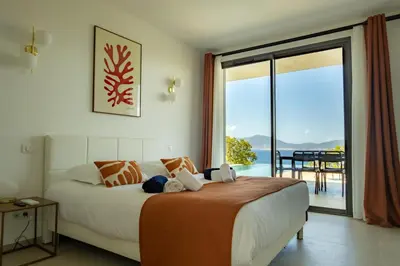 a bedroom with a bed with a view of the ocean at VILLA IMPERIALE vue mer piscine in Pietrosella