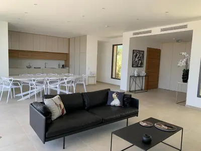 a living room with a black couch and a table at VILLA IMPERIALE vue mer piscine in Pietrosella