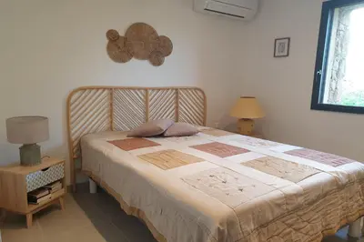 a bedroom with a bed with a wooden head board at U Caseddu di a Castagna Maison en pierre La Castagna Coti Chiavari in Coti-Chiavari
