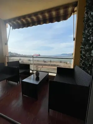 a room with a large window with chairs and a table at Le bord de mer in Propriano