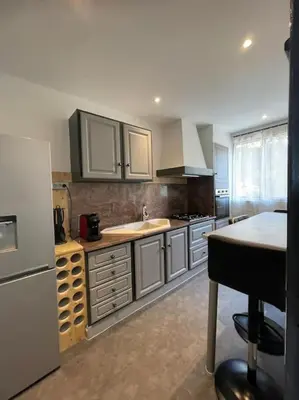 a kitchen with a white refrigerator and a sink at Le bord de mer in Propriano