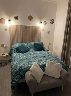 a bedroom with a bed with a blue comforter at Le bord de mer in Propriano