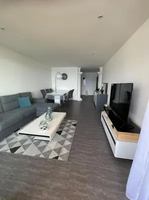 a living room with a couch and a tv at Le bord de mer in Propriano
