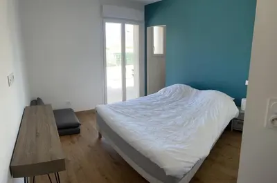 a bedroom with a bed and a wooden table at Maison de Vacances Avec Piscine Privée en Corse, BORGO in Borgo