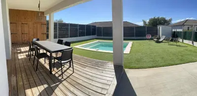 a deck with a table and chairs and a swimming pool at Maison de Vacances Avec Piscine Privée en Corse, BORGO in Borgo
