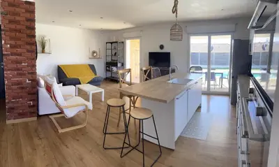 a kitchen and living room with a table and chairs at Maison de Vacances Avec Piscine Privée en Corse, BORGO in Borgo