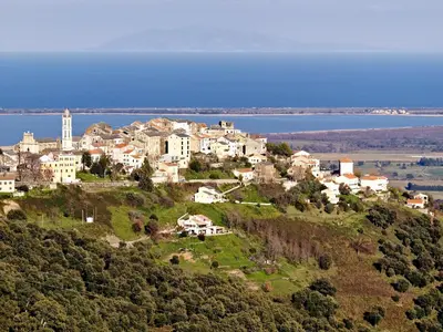 a town on top of a hill with the water at Maison de Vacances Avec Piscine Privée en Corse, BORGO in Borgo