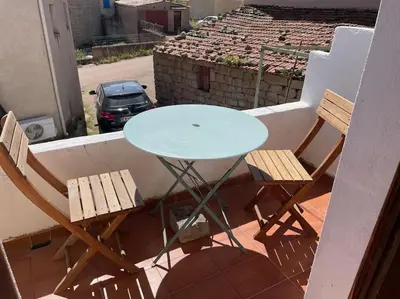 a table and two chairs sitting on a balcony at Charmante maison de village in Porto-Vecchio