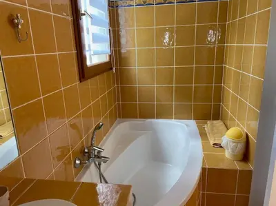 a bathroom with a white tub and a sink at Charmante maison de village in Porto-Vecchio