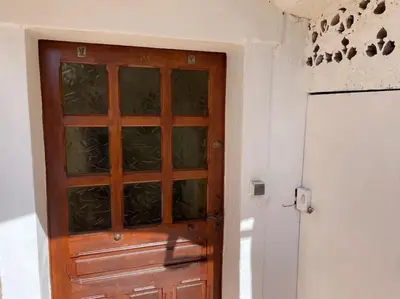a wooden door with a glass window in a room at Charmante maison de village in Porto-Vecchio