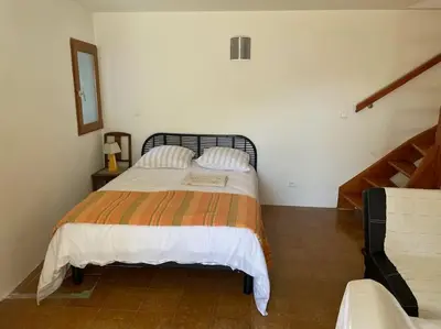 a bedroom with a large bed with two pillows at Charmante maison de village in Porto-Vecchio