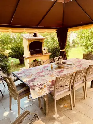 a dining table and chairs with an outdoor oven at Casa Mulinchese entre Mer et Montagne in Volpajola