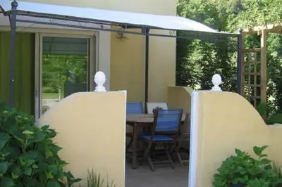 a patio with a table and chairs under a white awning at Casa Mulinchese entre Mer et Montagne in Volpajola