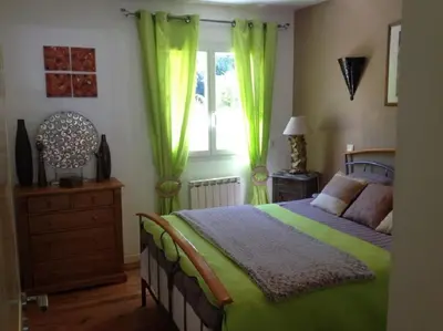 a bedroom with a bed with green curtains and a window at Casa Mulinchese entre Mer et Montagne in Volpajola