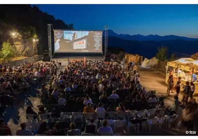 a crowd of people sitting in chairs in front of a screen at Casa1850 in Lama