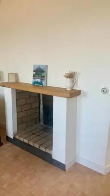 a table on a wall with a fireplace at Casa1850 in Lama