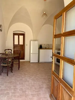 an open door to a kitchen with a table and a refrigerator at Casa1850 in Lama