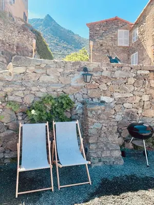 two folding chairs sitting next to a stone wall at Casa1850 in Lama
