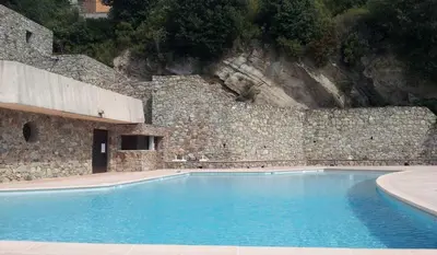 a large swimming pool in front of a stone wall at Casa1850 in Lama