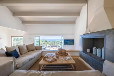 a living room with a couch and a fireplace at Superbe Villa Porto Vecchio vue mer plage à pied in Porto-Vecchio