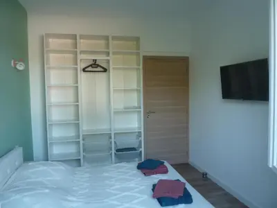 a bedroom with a bed and a tv and shelves at Soleil & mer sur la Costa Verde in Cervione