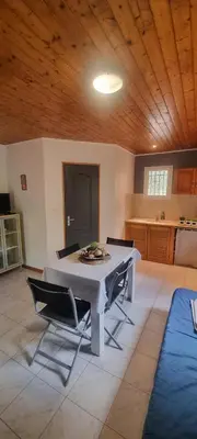 a kitchen with a table and chairs in a room at Résidence bord de mer I Querci in Poggio-Mezzana