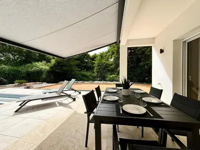 a dining room with a table and chairs on a patio at Casamea - Villa Familiale, Piscine, 15 min Ajaccio in Alata