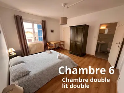 a small bedroom with a bed and a table at U pozzu hôtel in Evisa