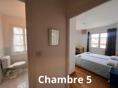a bedroom with a bed and a bathroom at U pozzu hôtel in Evisa