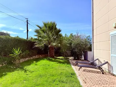 a bench sitting in the grass next to a building at Rare grand appartement standing terrasse et jardin - Porticcio proche mer in Porticcio