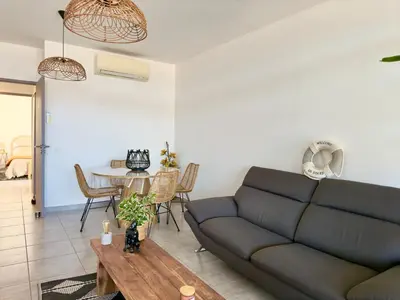 a living room with a couch and a table at Rare grand appartement standing terrasse et jardin - Porticcio proche mer in Porticcio