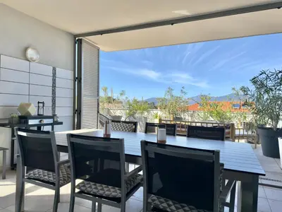 a dining room with a table and chairs on a patio at Rare grand appartement standing terrasse et jardin - Porticcio proche mer in Porticcio