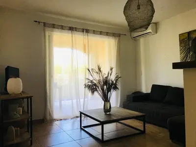 a living room with a couch and a table at Rez de chaussez de villa 4 personnes mer in Sorbo-Ocagnano