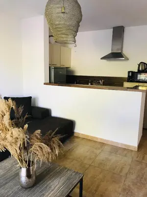a living room with a black couch and a table at Rez de chaussez de villa 4 personnes mer in Sorbo-Ocagnano