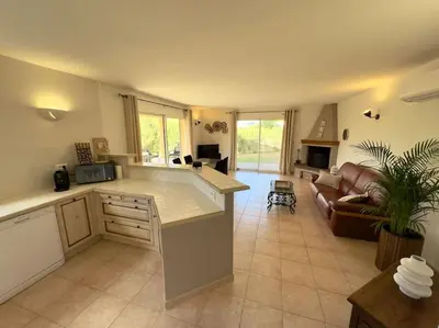 a large kitchen and living room with a couch at 72 m2 Centre-ville avec jardin in Porto-Vecchio
