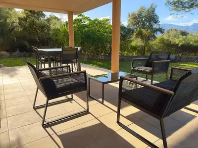 a group of chairs and tables on a patio at 72 m2 Centre-ville avec jardin in Porto-Vecchio