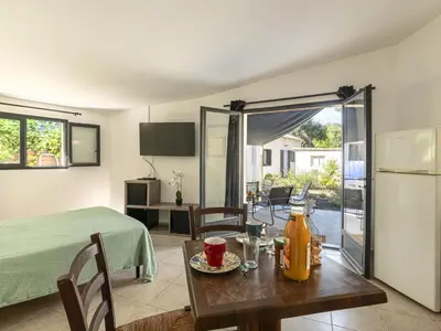 a kitchen and dining room with a table and a refrigerator at Studio Germaine by Interhome in Porto-Vecchio