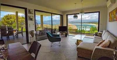 a living room with a couch and a table at PORTICCIO Maison vue mer in Porticcio