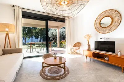 a living room with a couch and a tv and a table at Appartement 4-6 pers Bonifacio in Bonifacio