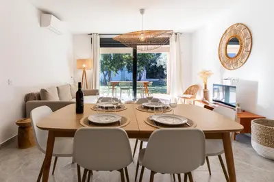 a dining room with a wooden table and chairs at Appartement 4-6 pers Bonifacio in Bonifacio