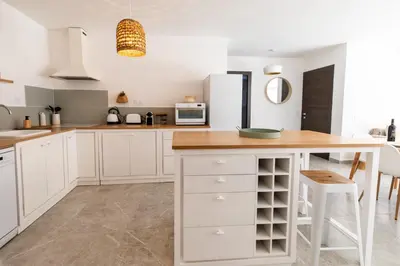 a kitchen with white cabinets and a wooden counter at Appartement 4-6 pers Bonifacio in Bonifacio