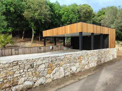 a building with a stone wall next to a road at Villa STEVAN in Bonifacio