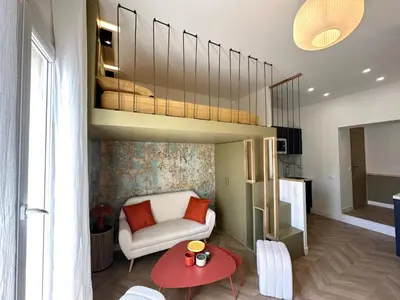 a living room with a bed and a chair and a table at Superbe studio centre Ajaccio in Ajaccio