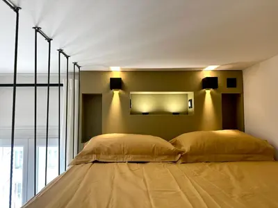 a bedroom with two beds and a mirror on the wall at Superbe studio centre Ajaccio in Ajaccio