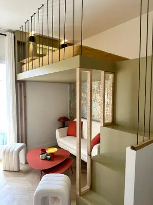 a living room with a loft bed and a red table at Superbe studio centre Ajaccio in Ajaccio