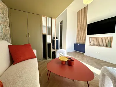 a living room with a red table and a couch at Superbe studio centre Ajaccio in Ajaccio