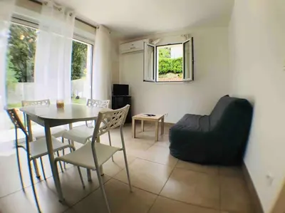 a living room with a table and chairs and a couch at Casa Bartoli, T2 Entre Mer et Montagne in Isolaccio-di-Fiumorbo