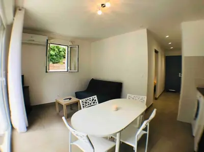 a living room with a white table and chairs at Casa Bartoli, T2 Entre Mer et Montagne in Isolaccio-di-Fiumorbo