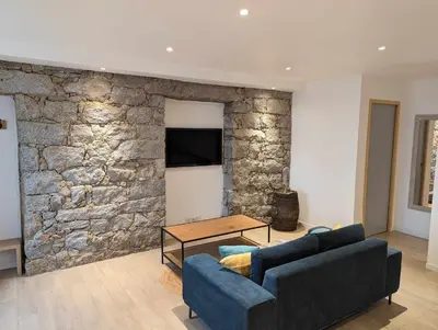 a living room with two couches and a stone wall at Appartement proche de Porto-Vecchio in Porto-Vecchio